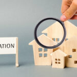 A poster with the word Valuation and a miniature wooden house. Real estate appraisal. Rate the property / home. Appraisal services. Evaluation. Apartments, housing. Appraiser